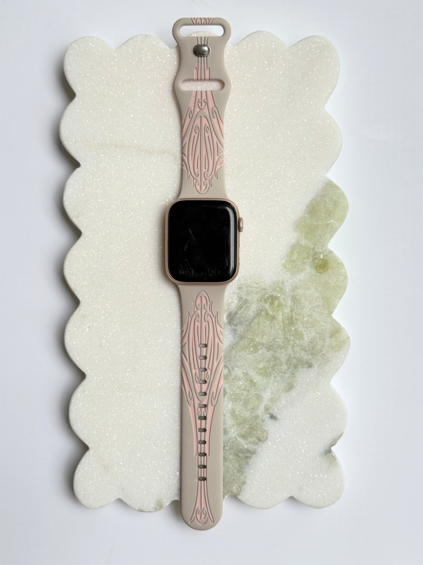 Smartwatch with a decorative band on a textured white surface